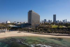 テルアビブにあるThe Vista At Hilton Tel Avivの高層建築物が立ち並ぶ街の前のビーチ