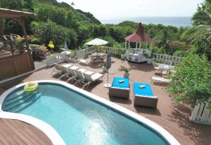 a swimming pool on a deck with chairs and a gazebo at Amazing 9 BR Villa in Cap Estate in Cap Estate