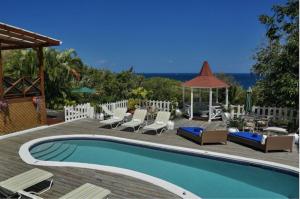 a swimming pool with chairs and a gazebo at Amazing 9 BR Villa in Cap Estate in Cap Estate