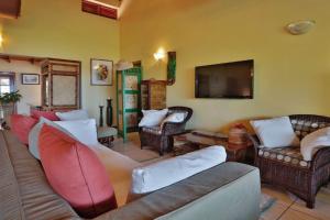 ein Wohnzimmer mit Sofas und einem Flachbild-TV in der Unterkunft Amazing 9 BR Villa in Cap Estate in Cap Estate