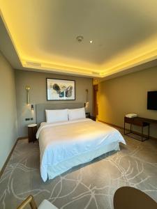 a bedroom with a large white bed and a flat screen tv at The address opera t1 burj khalifa in Dubai