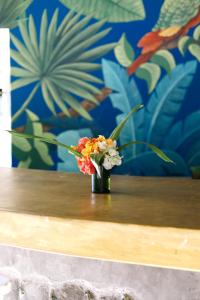 um pequeno vaso de flores sentado numa mesa em Watamu Beach Cottages em Watamu