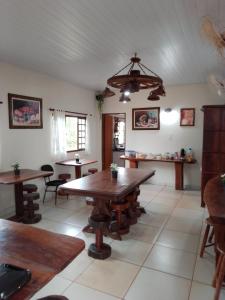 a dining room with a wooden table and chairs at Pousada Estância Mineira in Campo Grande