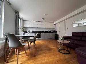 a living room with a table and a couch at Apt 3, Soho Apartments 2nd & 3rd floors by Indigo Flats in London