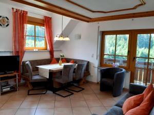 a living room with a table and chairs and a tv at Schlosshof - der Urlaubsbauernhof in Elzach