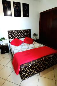 a bedroom with a large bed with red pillows at Residence salam in Agadir