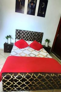 a bedroom with a black and red bed with red pillows at Residence salam in Agadir