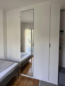 a bedroom with a mirror and two beds in it at Cozy studio Bečići in Becici