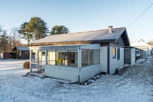 a small house in the snow in a yard at Holiday home within walking distance to sandy beach in Båstad