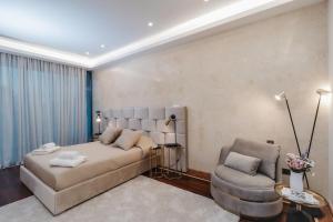 a bedroom with a large bed and a chair at 16 EXECUTIVE SUITES in Nicosia