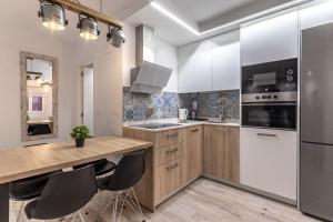 a kitchen with white cabinets and stainless steel appliances at Bilbao Park III with parking by Aston Rentals in Bilbao