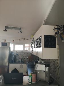 eine Küche mit weißen Schränken und einer Arbeitsplatte in der Unterkunft Yumbo room in Maspalomas