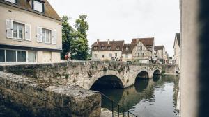 eine Steinbrücke über einen Fluss in einer Stadt in der Unterkunft Le Spacieux in Chartres
