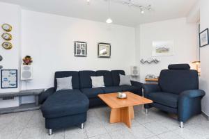 ein Wohnzimmer mit einem Sofa und 2 Stühlen in der Unterkunft Ferienhäuser Deichkrone in Bensersiel