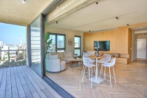 een woonkamer met een bank en een tafel en stoelen bij High End 1BD Beach Apartment in Tel Aviv