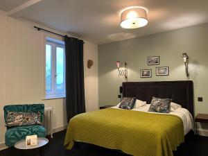 a bedroom with a bed and a chair and a window at The Originals Boutique, Hôtel La Colonne de Bronze, Saint-Valéry-sur-Somme (Inter-Hotel) in Saint-Valery-sur-Somme