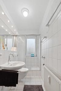 a white bathroom with a sink and a shower at Stadt-Apartment 3 Zimmer mit Terasse in Hannover