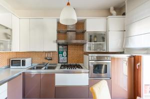 a kitchen with white cabinets and stainless steel appliances at Mestre Cozy Apartment with Parking! in Marghera