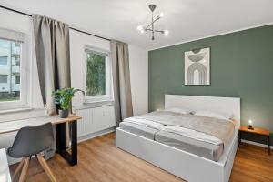 a bedroom with a bed and a desk and windows at Stadt-Apartment 3 Zimmer mit Terasse in Hannover