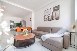 een woonkamer met een bank en een tafel bij Cosy flat for 6 people #2 in Asnières-sur-Seine