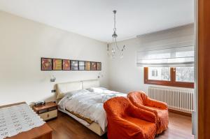- une chambre avec un lit et une chaise dans l'établissement Mestre Cozy Apartment with Parking!, à Marghera
