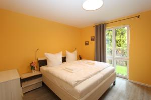 a bedroom with a large bed and a window at Haus Sterntaucher Appartement 4 in Thiessow