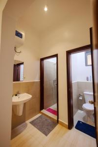 a bathroom with a shower and a toilet and a sink at 1 Bedroom Lake Victoria View Apartment in Entebbe