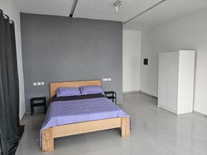 um quarto com uma cama com um cobertor roxo em Dreamhouse Bellavista em Lomé