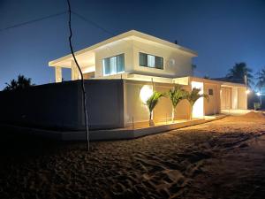 una casa blanca con palmeras delante en Dreamhouse Bellavista, en Lomé