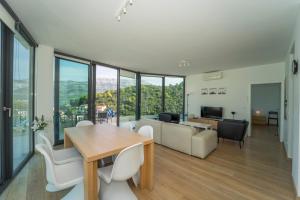 uma sala de estar com uma mesa e cadeiras e um sofá em White Cloud Apartments em Korčula