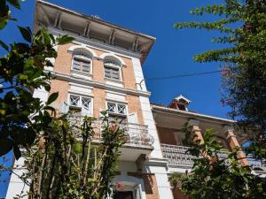 a tall brick building with white windows and a balcony at Le Manoir in Antananarivo