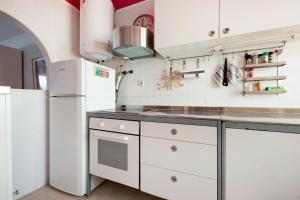 a kitchen with white cabinets and a white refrigerator at Very well maintained house in Chayofa, the sunny south of Tenerife in Chayofa