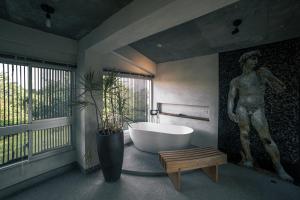a bathroom with a tub and a statue of a man at 57villa in Hengchun South Gate