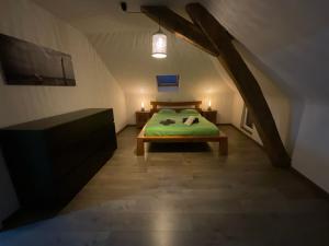ein Schlafzimmer mit einem grünen Bett im Dachgeschoss in der Unterkunft Maison 3 chambres proximité aéroport et grand axes in Charleroi
