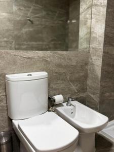 La salle de bains est pourvue de toilettes blanches et d'un lavabo. dans l'établissement Santiago, à Paraná