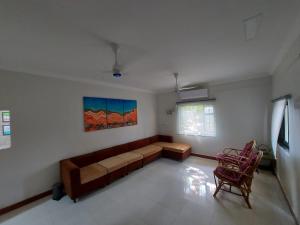 een woonkamer met een bank en 2 stoelen bij LAKSHMI FARM in Alibaug