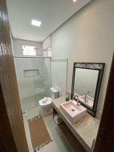 a bathroom with a sink and a toilet and a mirror at Apt. Ah-Mar in Porto Seguro