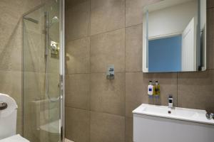a bathroom with a shower and a sink and a mirror at Housel Bay Hotel in Lizard