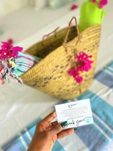 a person holding a card in front of a purse with flowers at Watamu Beach Cottages in Watamu