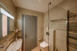 y baño con ducha, aseo y lavamanos. en Alika Resort, en Álika