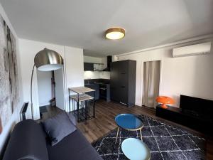 a living room with a blue couch and a kitchen at Sublime T2 avec balcon in Montauban