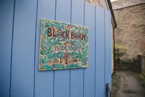 Hidden Oasis in the heart of Kingsbridge في كينغسبريدج: علامة على جانب الجدار الأزرق