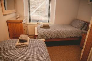 a bedroom with two twin beds and a window at Hidden Oasis in the heart of Kingsbridge in Kingsbridge