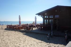 a building on the beach with tables and chairs at Mieszkanie Przy Plaży in Gdańsk