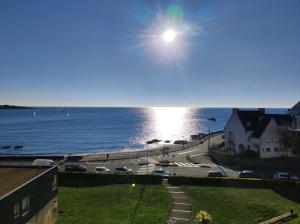 una vista del océano con el sol en el cielo en L'Escale - Appartement vue mer, en Concarneau