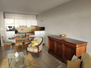 a living room with a kitchen and a dining room at L'Escale - Appartement vue mer in Concarneau