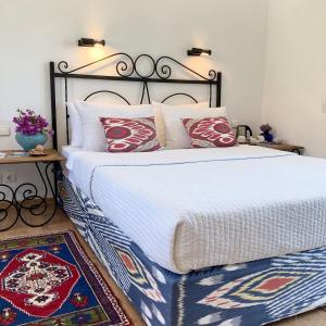 a bedroom with two beds with red and white pillows at Hotel Villa Tokur in Datca