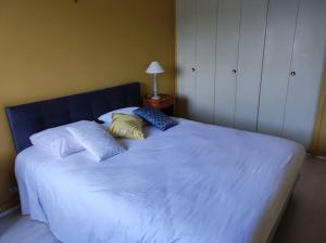 Una cama blanca grande con dos almohadas encima. en L'Escale - Appartement vue mer, en Concarneau