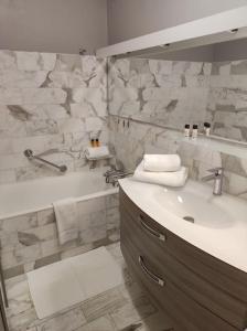 Un baño con lavabo, espejo y bañera. en L'Escale - Appartement vue mer, en Concarneau