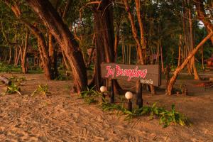 a sign in the sand in front of some trees at JOY Bungalow Resort and Restaurant in Ko Jum